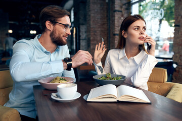 cheerful young couple in cafe breakfast work colleagues lifestyle