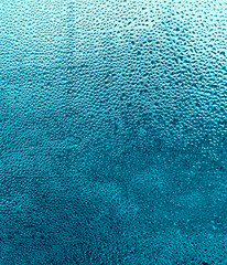 Raindrops on a cyan glass background.