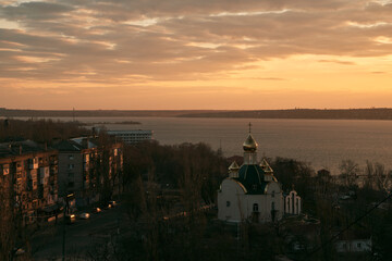 astern Orthodox Church on the river. Sky moving with god rays. Skylapse of the church with golden domes. Dome of the church reflecting floating sky