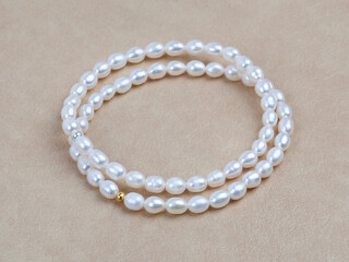 Luxury elegant baroque pearl bracelets on beige textured leather background