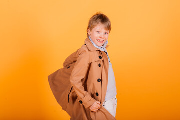 Grimacing emotional redhead fasion boy posing in yellow studio
