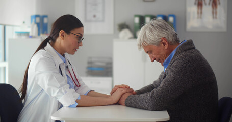 Portrait of female doctor talking to upset aged patient discussing diagnosis and treatment