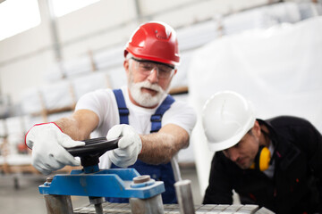 Portrait of workers in factory. Colleagues with helmet working in factory.