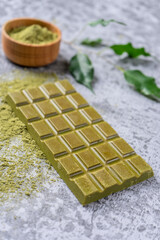 Handmade chocolate on a gray background (concrete). Sencha green tea.