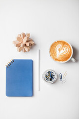 office desk workspace with notebook, pen, coffee, puzzle and paper clips in glass jar. Flat lay, top view, business, work, concept. copy space.