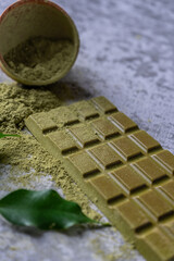 Handmade chocolate on a gray background (concrete). Sencha green tea.