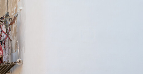 Facade painting scaffolding and painters with paint roller