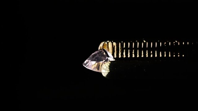 natural morganite gemstone in tweezer on the turn table