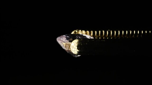 natural morganite gemstone in tweezer on the turn table