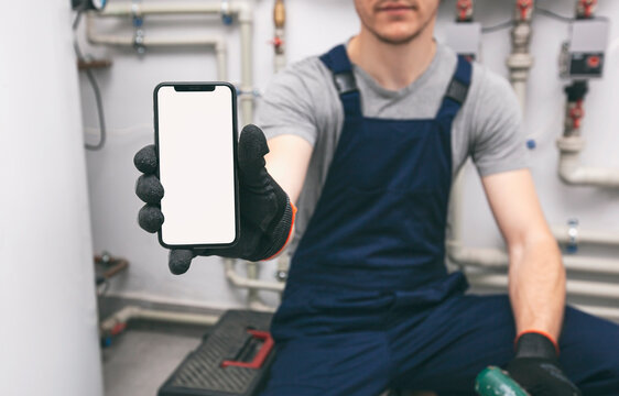 White blank screen mobile phone in plumber's hand in protection gloves