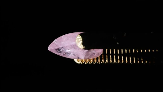 natural morganite gemstone in tweezer on the turn table