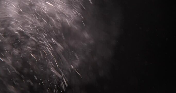 Explosion particles of white powder on black background 