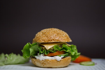 cheeseburger close-up with salad cutlet and sesame seed bun