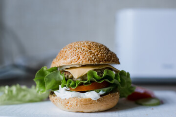 cheeseburger close-up with salad cutlet and sesame seed bun