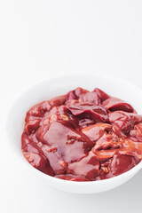 raw chicken liver in a white plate on a white background. Mockup 