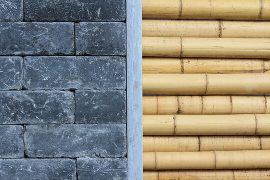 Mauer aus dicken Bambusrohren und schwarzen Steinen