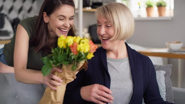 Daughter giving her mother flowers and gift card. Shot with RED helium camera in 8K.
