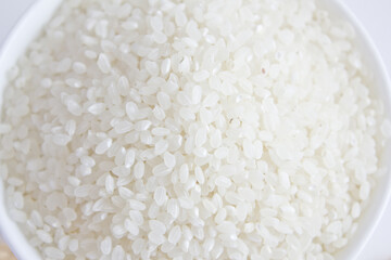 rice grains in a bowl isolated on white background.