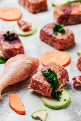 Composition with raw square cutlets on light background. Natural food for dogs. BARF dog diet