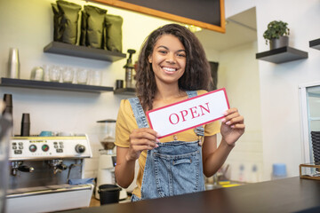 Woman at bar counter with sign that says open