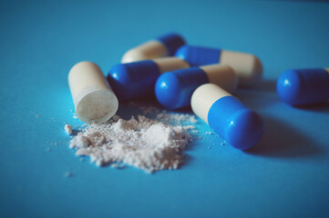 big blue white pills in capsules with white powder medicine pharmacy pharmaceuticals health supplements 