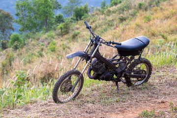 Plakat Modifying an old two-stroke motorbike with motocross tires For hiking and fun in the forest