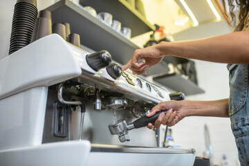 Female hands cleaning filter from coffee machine
