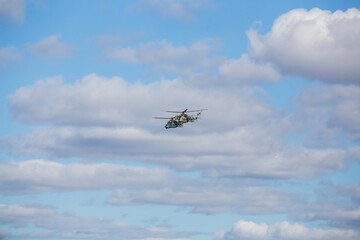an air show in the sky during a city holiday. the country's air force demonstrates aerobatics flying over the audience. combat helicopters and planes on a show-off performance