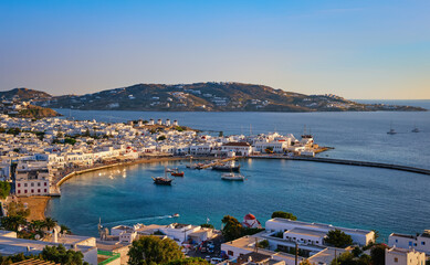 Obraz premium Beautiful sunset, colorful view, Mykonos, Greece. Bay, port, cruises, ship, whitewashed houses. Vacations, leisure, Mediterranean lifestyle