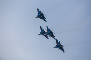 military aircraft fly at low altitude over the audience during the air show. patriotic military holiday. demonstration performance of professional pilots at the airshow