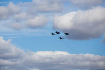 military aircraft fly at low altitude over the audience during the air show. patriotic military holiday. demonstration performance of professional pilots at the airshow