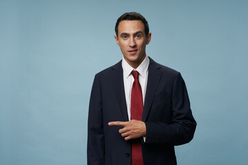 business man in a suit points his finger to the side Copy Space blue background