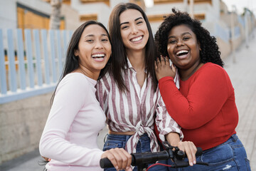 Happy latin girls having fun together outdoor with city background - Main focus on center woman face