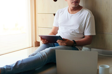 Man using a tablet in the living room of his home