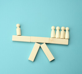 wooden figures of men on a swing, the group outweighs the loner. The concept of conflict of...