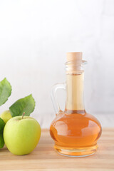 apple vinegar in glass bottle with fresh green apple on table 