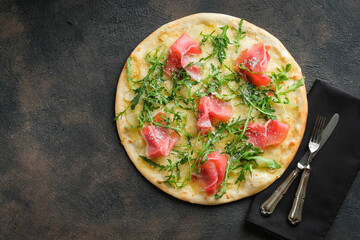 Pizza on dark background with knife and fork top view with copy space. Food delivery.