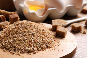 Fresh breadcrumbs and eggs on table, closeup