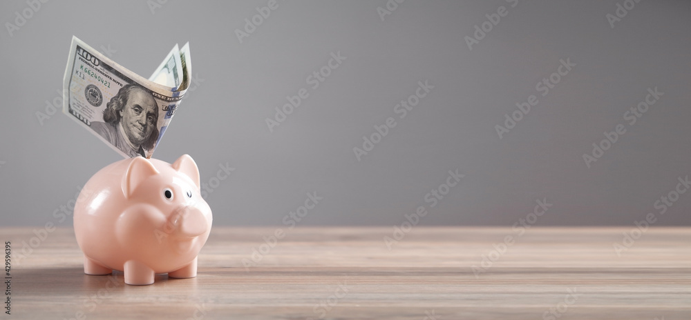 Wall mural Piggy bank and money on the desk. Saving. Business