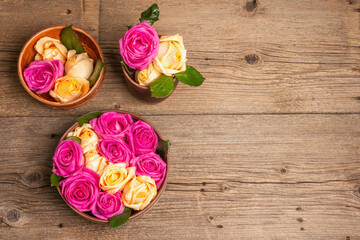 Composition of fresh multicolored roses in kitchen utensil