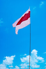 
Isolated waving Belarusian national flag on blue sky background with clouds . White-red-white flag. A symbol of peaceful protests in Belarus against the dictatorship after presidential elections.