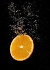 Orange slice falling in water