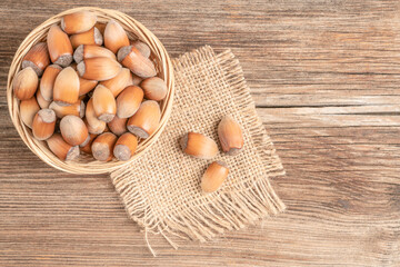 hazelnuts with nutshells in the basket on a wooden table