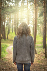 Woman from behind reflecting in the middle of the forest