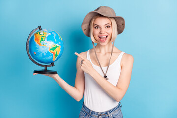 Portrait of funny astonished lady open mouth indicate finger hand hold globe isolated on blue color background