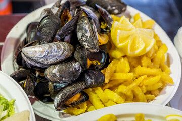 Plato con mejillones en un puesto del mercado de peces en el puerto de Bargen en Noruega