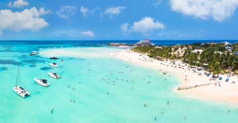 Beach in the Caribbean ocean with people and boats