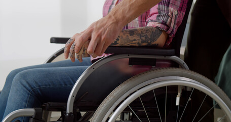 Obraz premium Cropped shot of disabled woman in wheelchair holding boyfriend hand