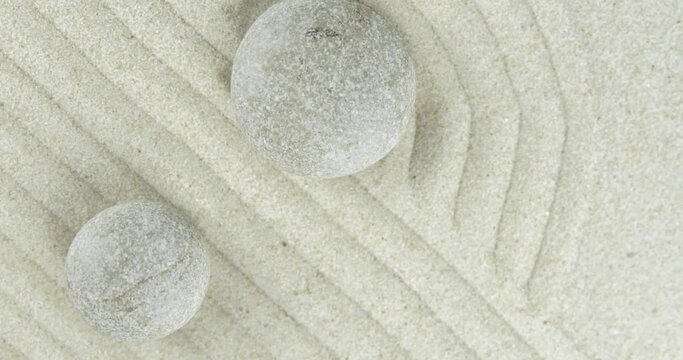 4k video Zen garden. Pyramids of white and gray zen stones on sand with abstract wave drawings. Concept of harmony, balance and meditation, spa, massage, relax.