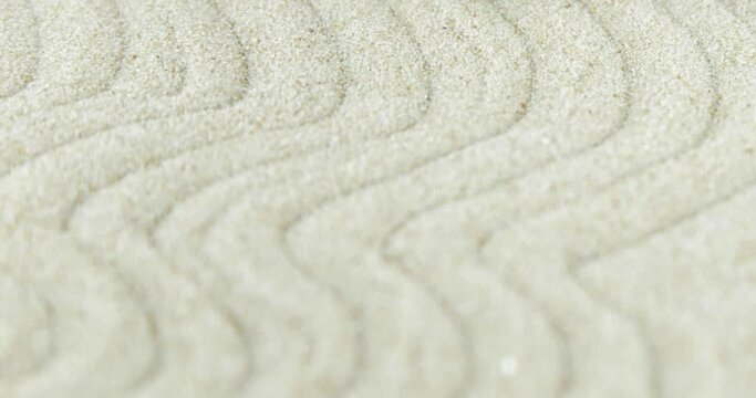 4k video Zen garden. Pyramids of white and gray zen stones on sand with abstract wave drawings. Concept of harmony, balance and meditation, spa, massage, relax.